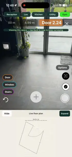 SiteSurvey on a phone during a room-by-room walk survey — named spaces listed along the top, a door opening measured on screen, and the live floor plan drawing itself underneath as the surveyor moves through the building